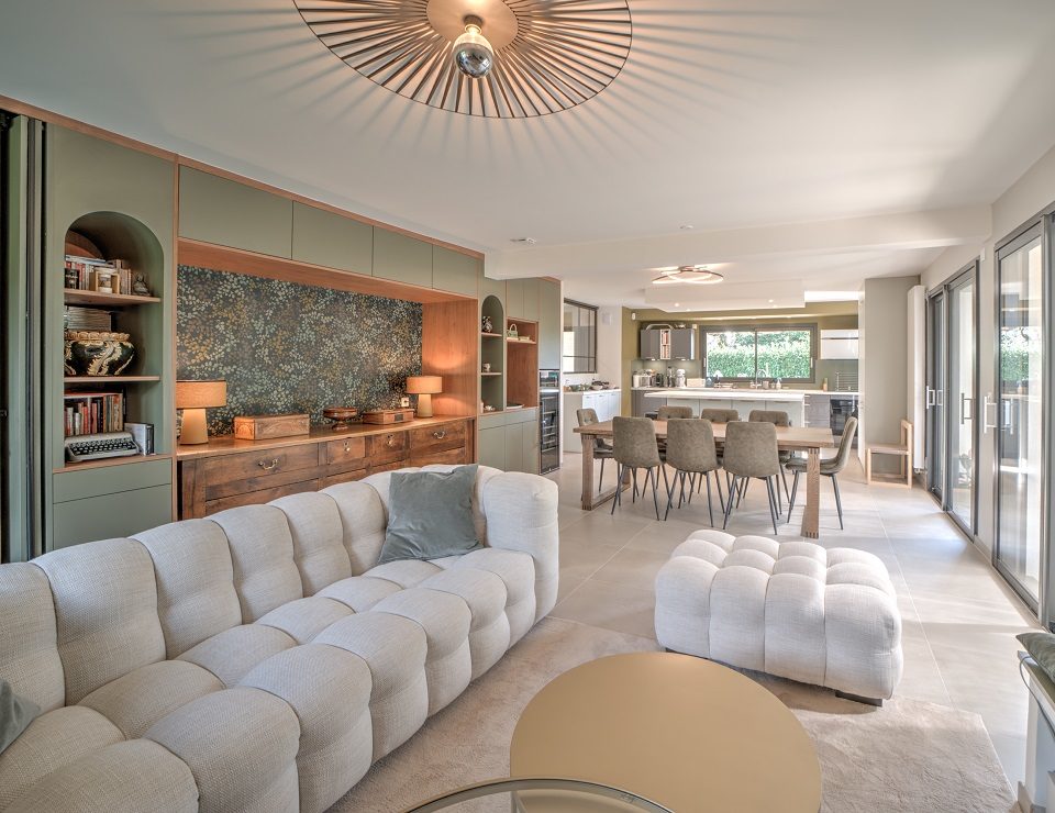 Pi&egrave;ce de vie ouverte avec salon contemporain, salle &agrave; manger et cuisine dans une villa de 150 m&sup2;.